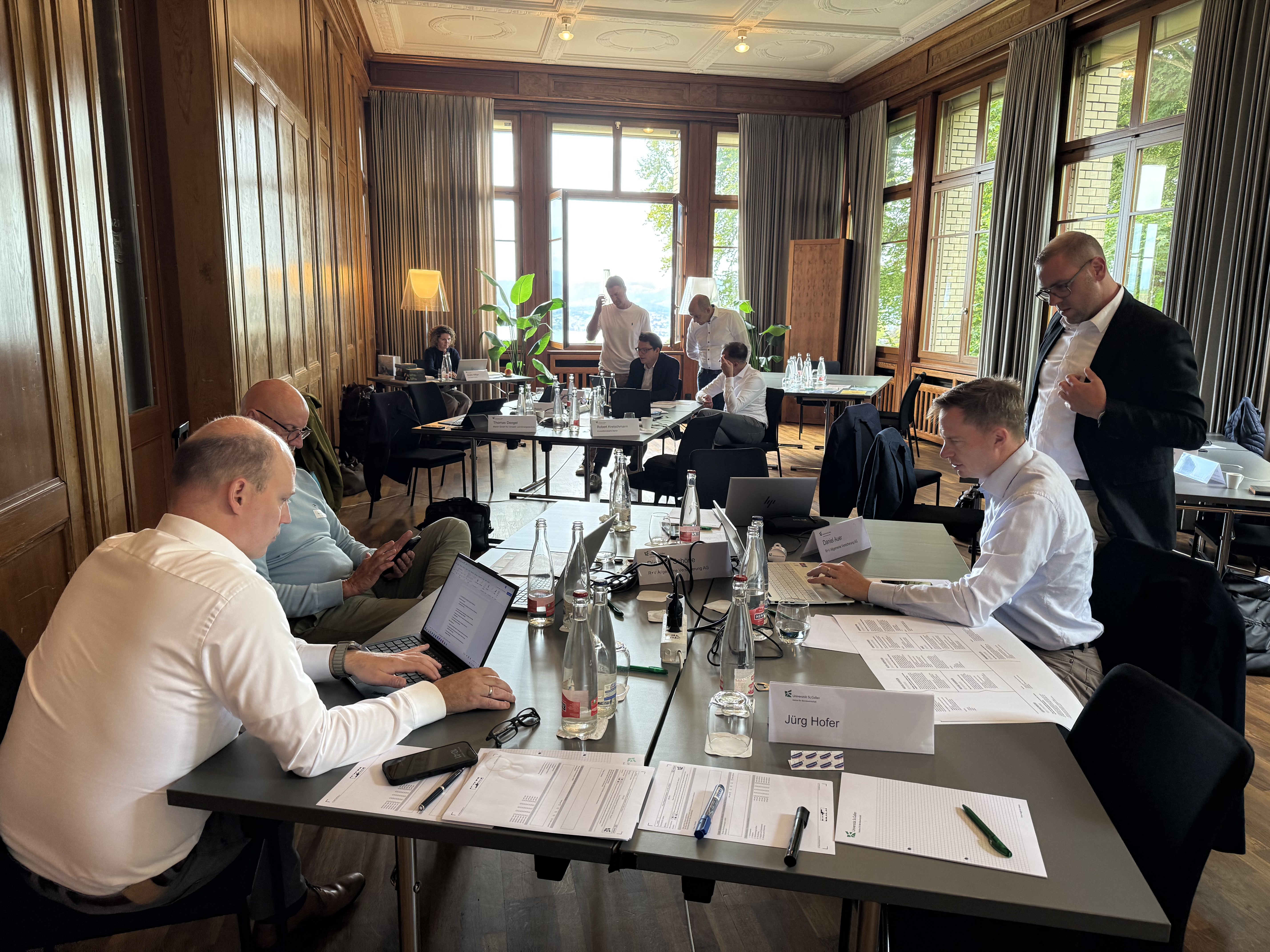 Teilnehmende arbeiten gemeinsam im Seminarraum an ihren Fragestellungen